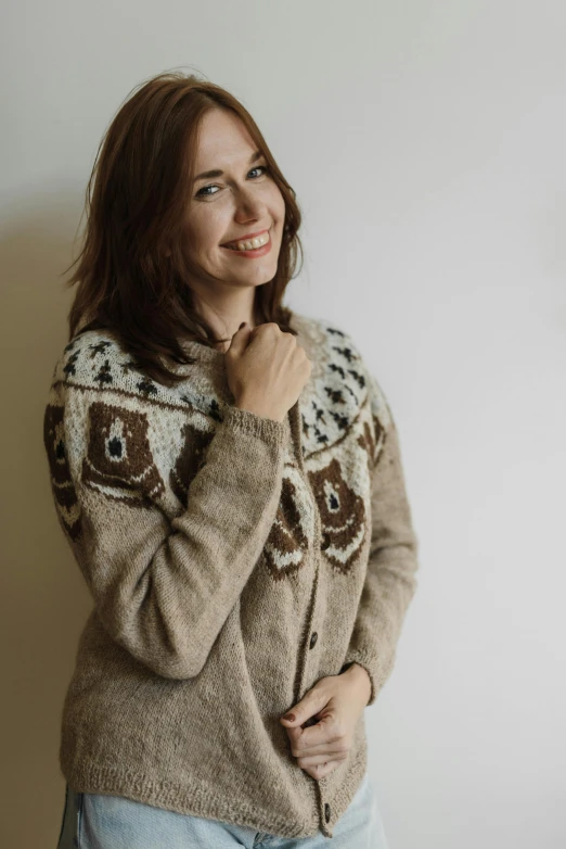 a woman smiling as she holds her hands near her ear