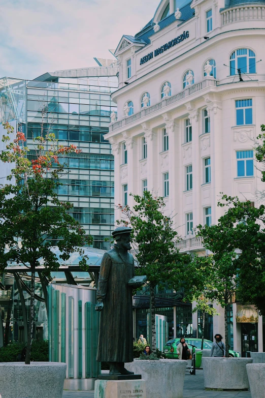 a statue sitting in a plaza surrounded by trees