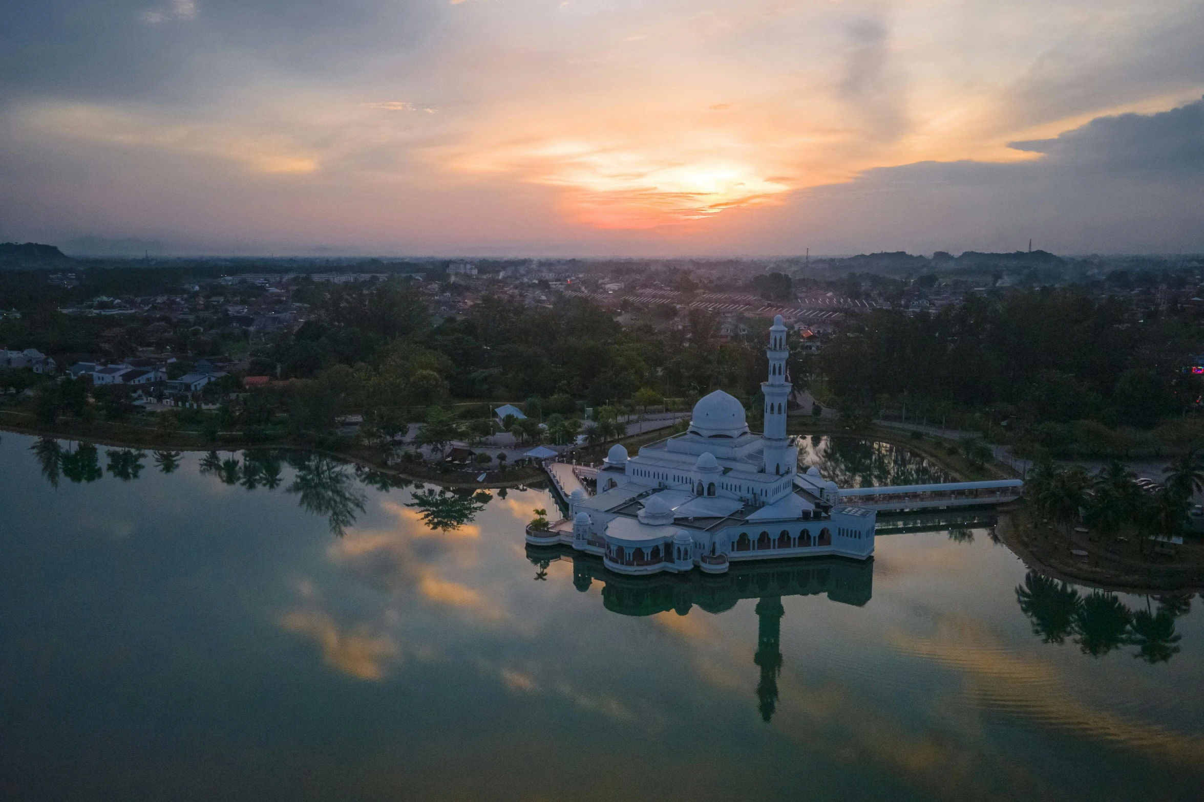 a mosque stands in the middle of a body of water