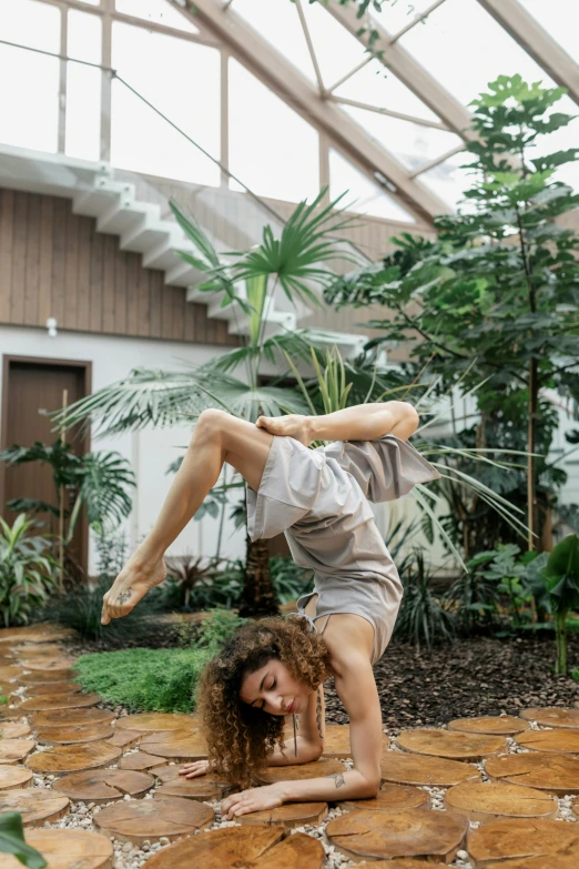 a woman is doing somersanas in the middle of a yard