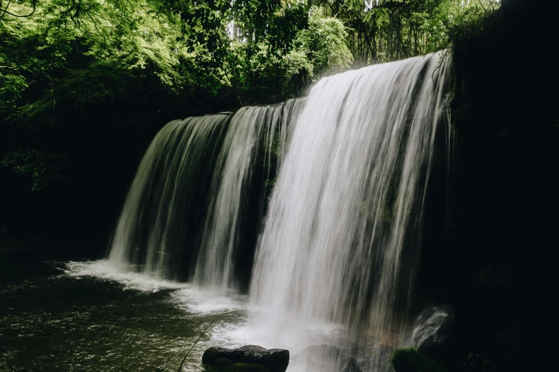 large waterfall in a lush green forest area