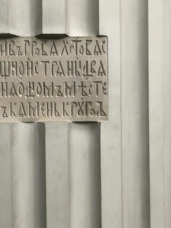 a carved stone sign is mounted to a wall