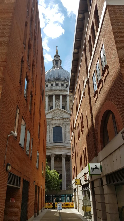 a narrow alley in the city with an old building