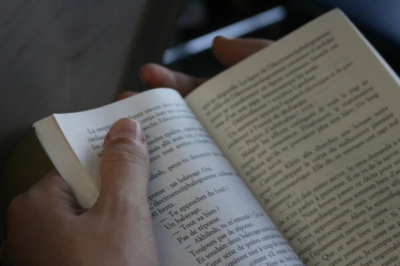 a person holding onto an open book