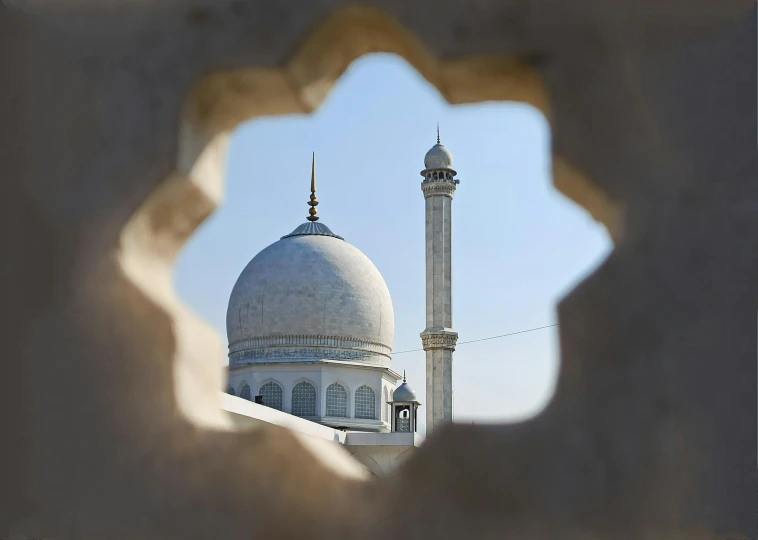 a tall white building with a minaret behind it