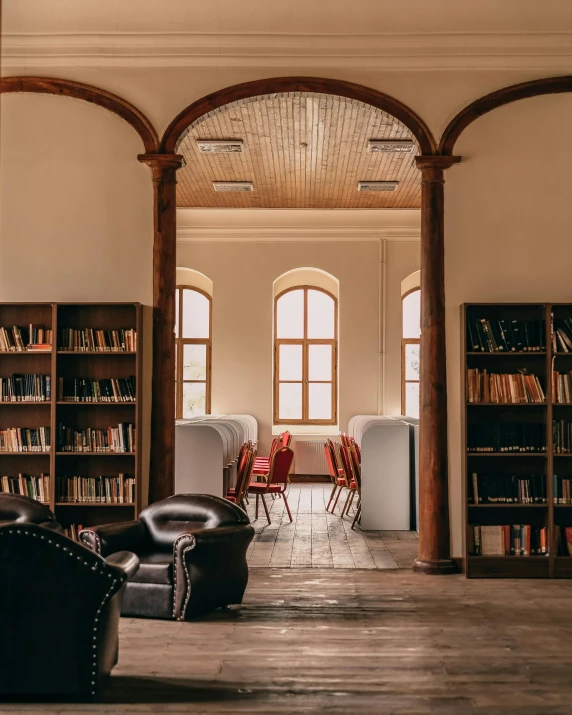 a liry with lots of books, chairs and tables