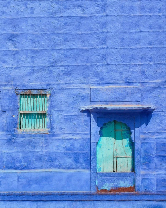 blue building with two window and shutters