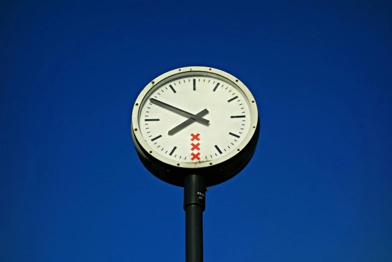a big black clock that has been placed next to the sky