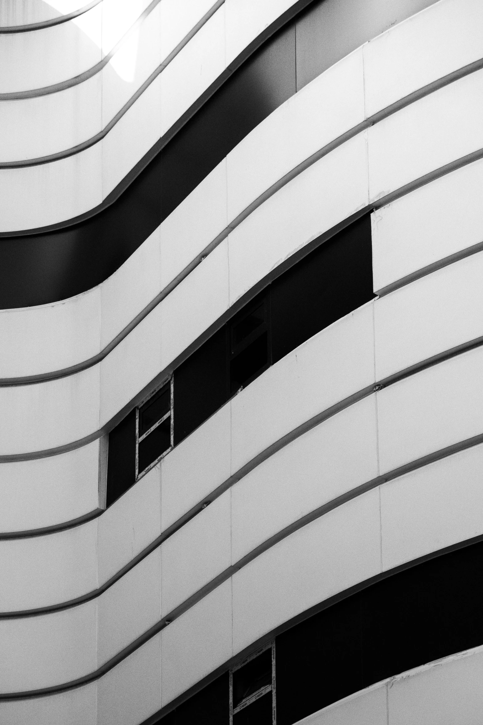 a black and white pograph of a building with the sun in the background