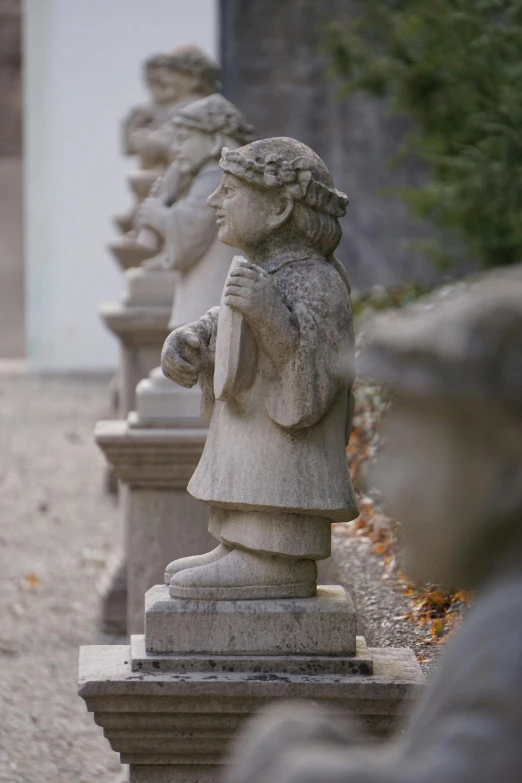 a line up of cement statues sitting outside