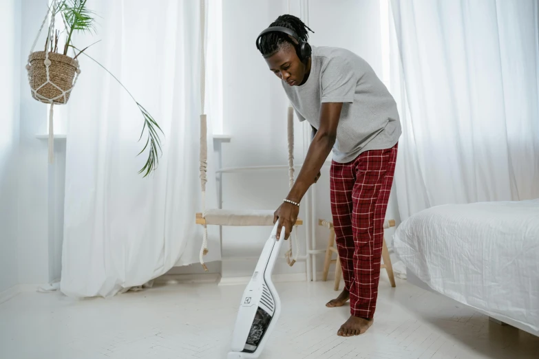 a woman is standing next to a bed