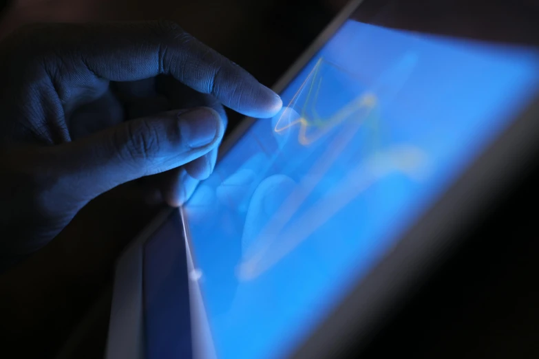 a hand is typing on a tablet device