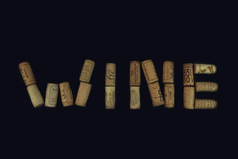 cork type wine laying on a table and the words wine spelled by the corks