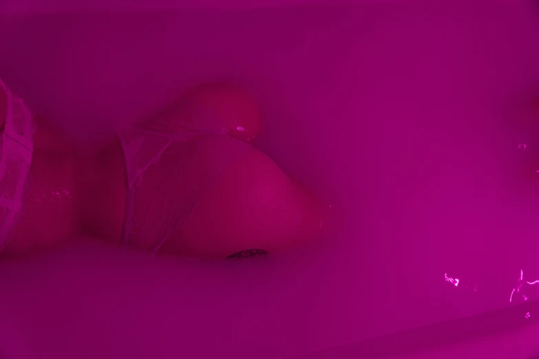 a pink object in a white sink with lots of water