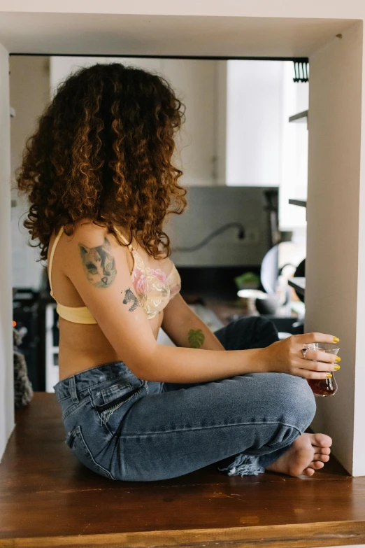 young black woman sitting cross - legged on a kitchen counter