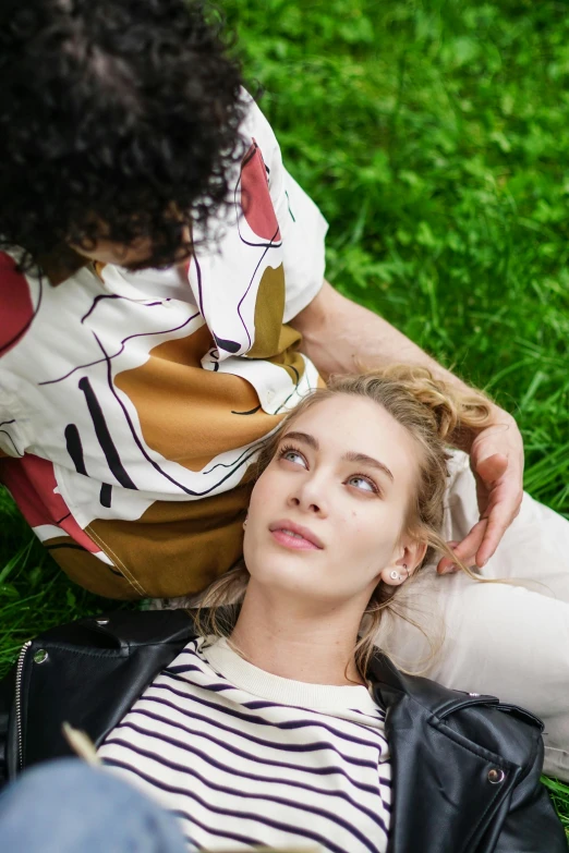 a woman is laying on the grass by herself