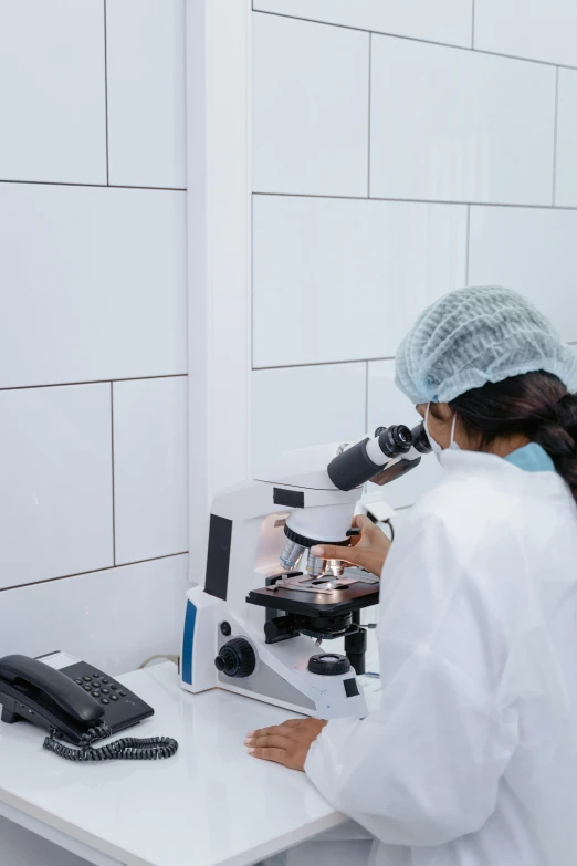 female scientist performing research in small white laboratory