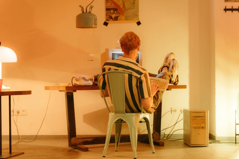 a woman sitting at a wooden table with her laptop computer