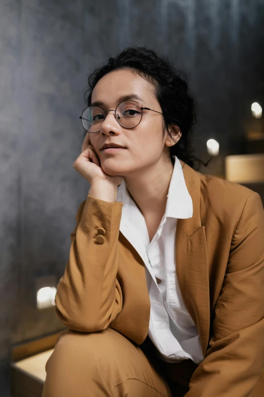 the woman is posing for a picture wearing a tan blazer