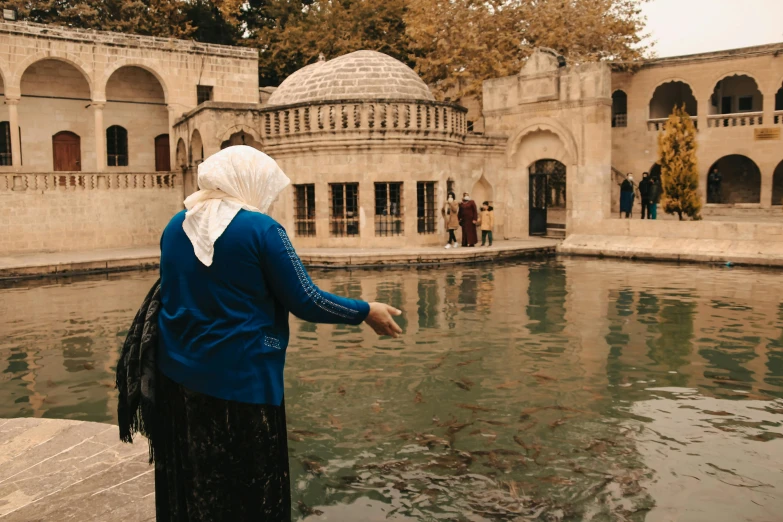 an old woman standing at the edge of a pool