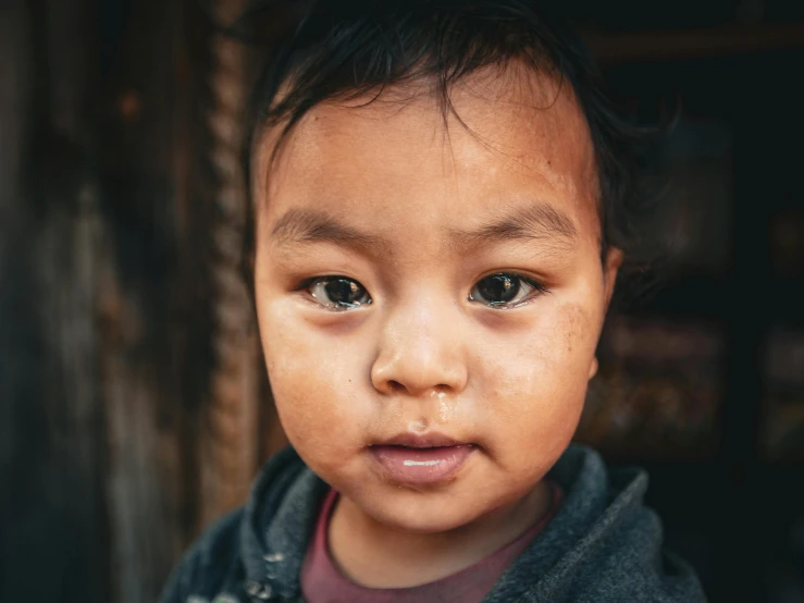 a little boy is standing with brown hair