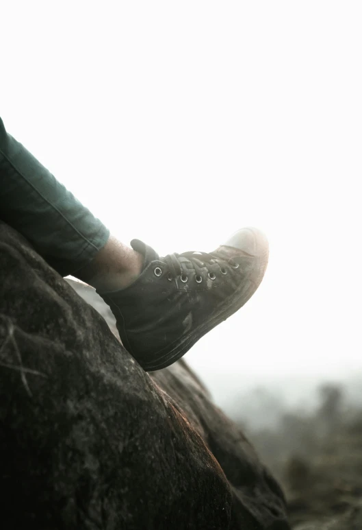 there is someone's foot resting on a large rock