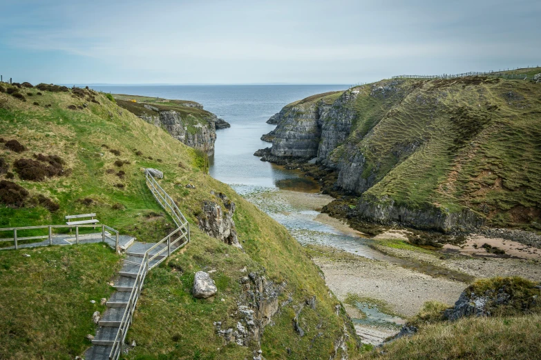 stairs lead up to a rock ledge near the ocean