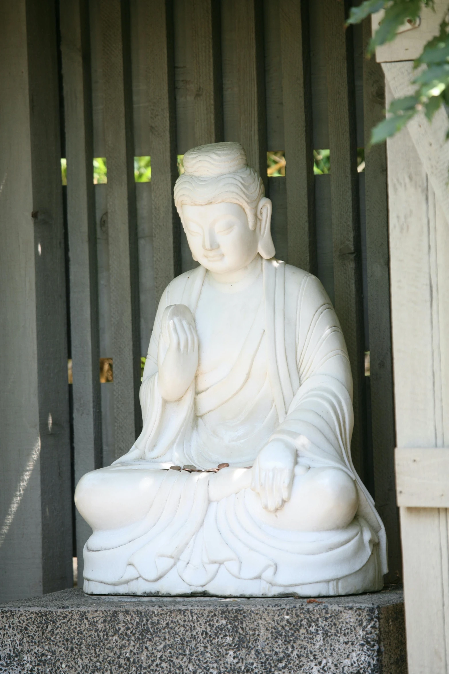 a buddha statue sitting on the outside of a building