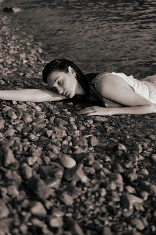 a beautiful woman laying down in a black and white po