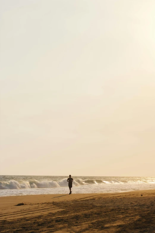 a man stands on a beach and looks at the water