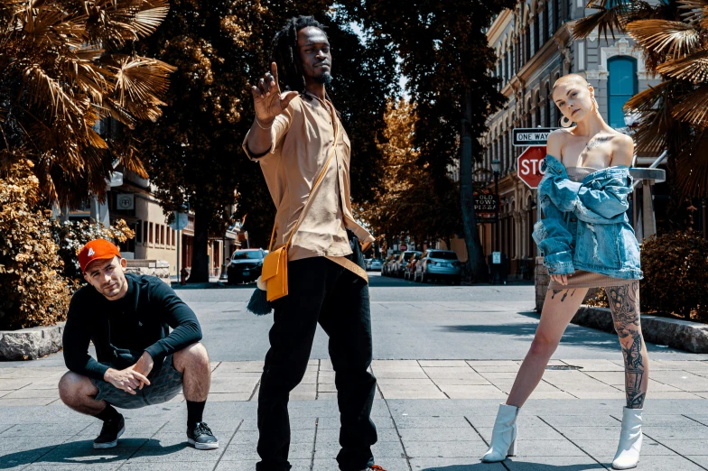 three models are posing with one holding a bag