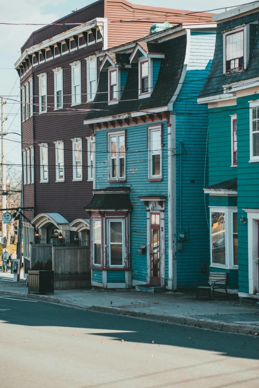 several blue houses in a row are painted many different shades of blue