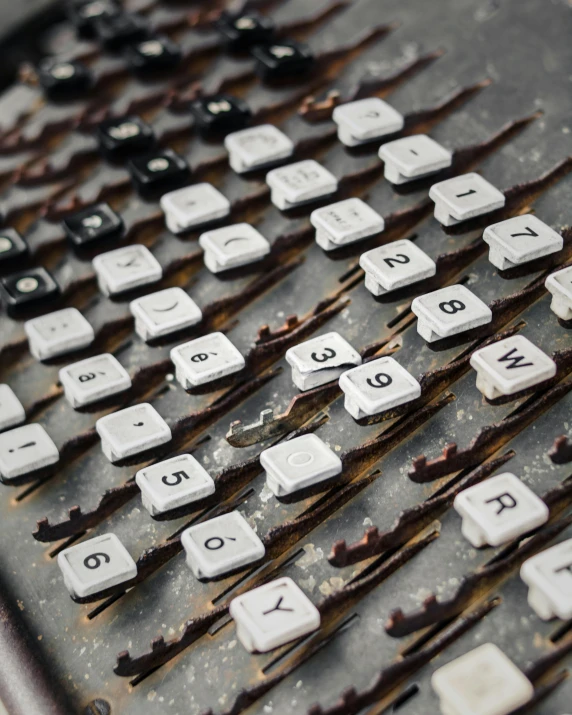 a lot of old, dirty keys laying on a metal surface