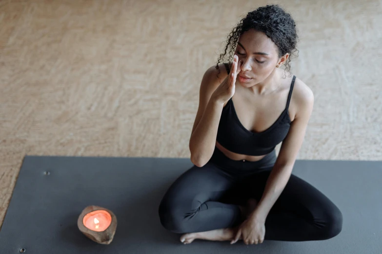 a woman doing yoga poses while looking at a small candle