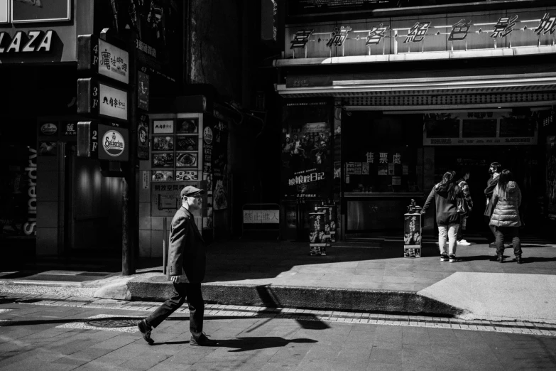 an older man walking in the street with another older man in front