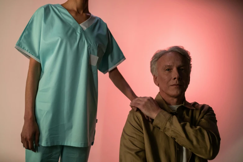 an old man holds onto the shoulder of a female surgeon