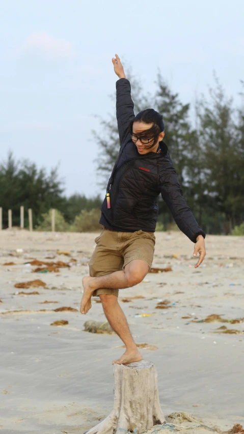 the person is standing on the sand by the trees