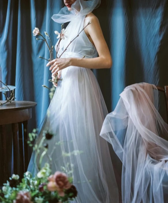 a woman in a wedding gown holding flowers