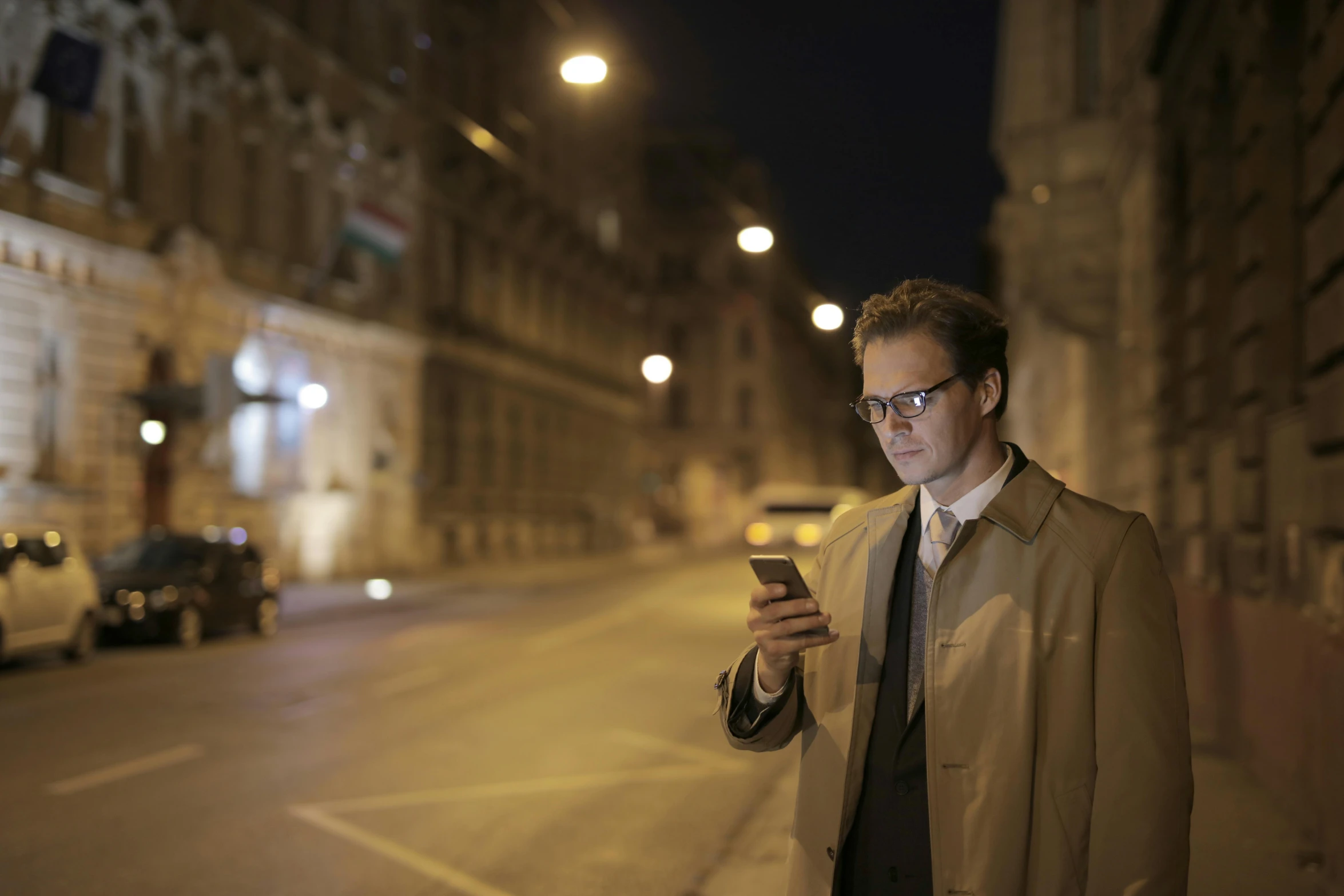 a man walking down the street while checking his cellphone