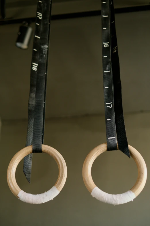 two black ribbons holding measuring tapes and ring rings