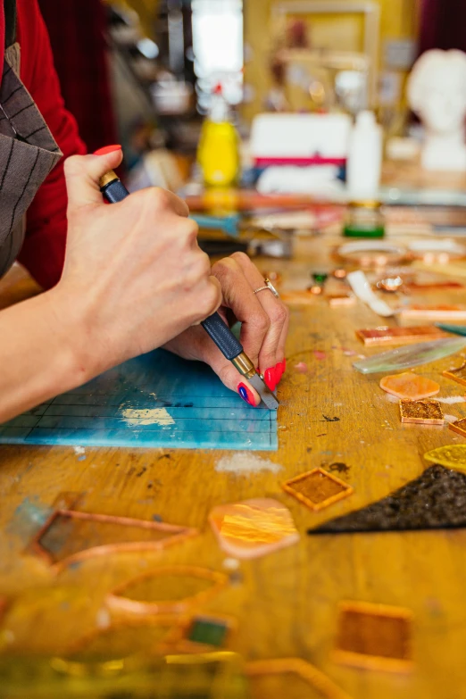 someone draws on a piece of art with colored markers