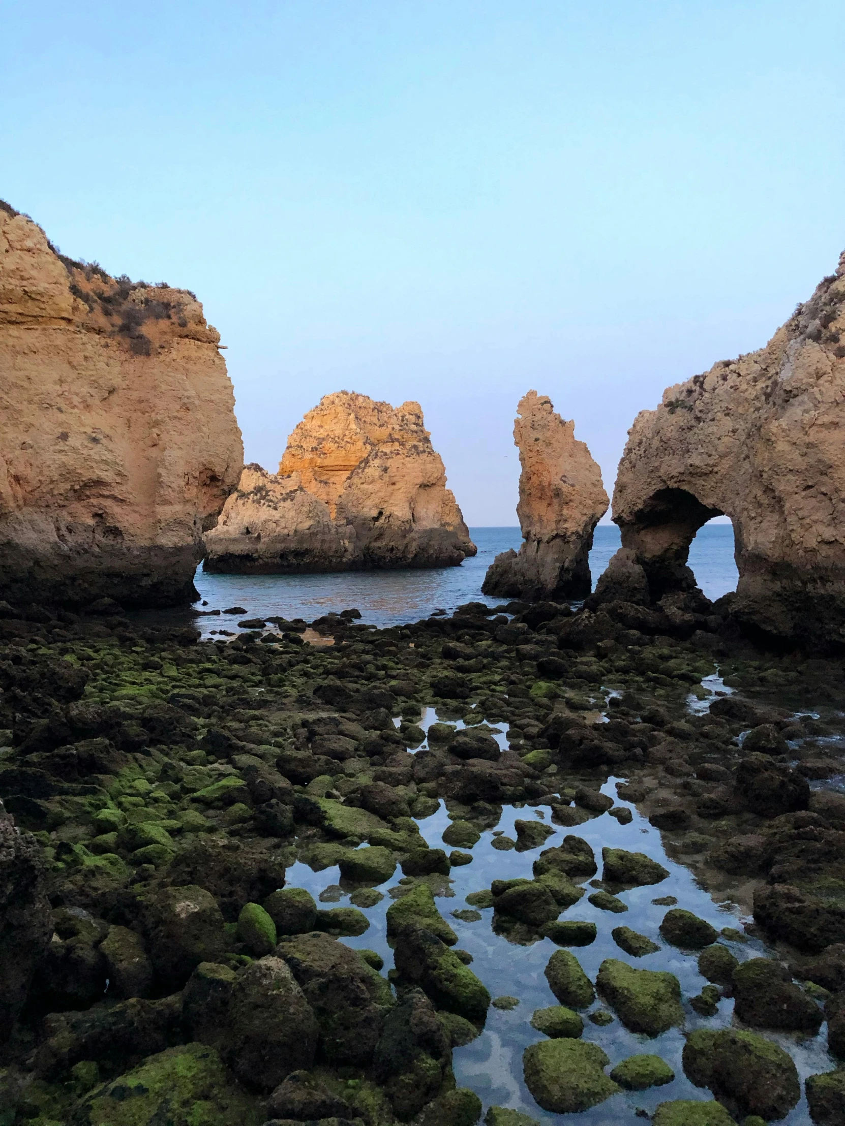 some big rocks and water that have moss growing on them