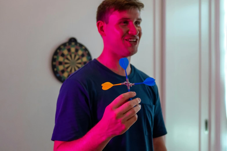 a young man smiling while holding a plastic spoon and fork