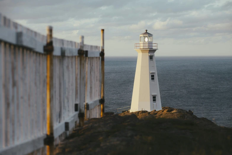 a white light house in the ocean, near the shore