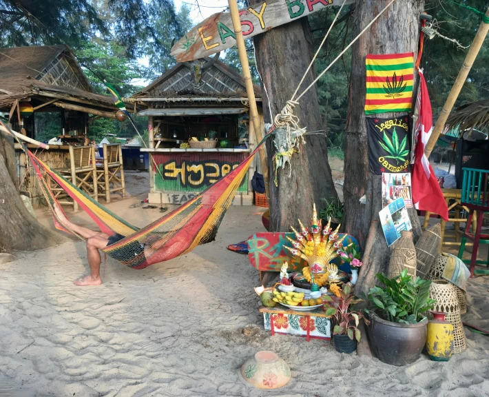 woman resting in a hammock between two tropical huts