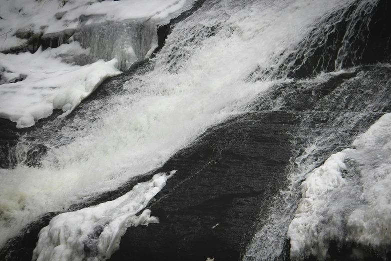 water flowing over large ice covered rocks