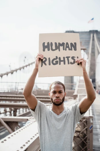 man holds a sign that says human rights