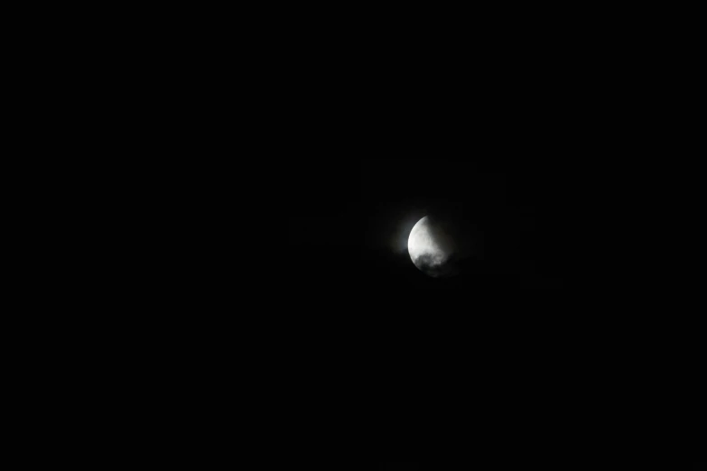 the moon partially visible in a dark night sky