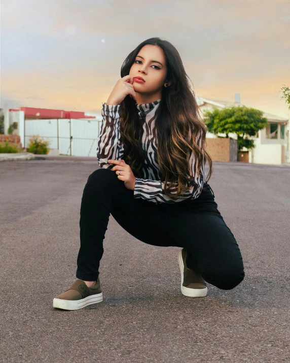 a girl with long hair poses in an empty lot