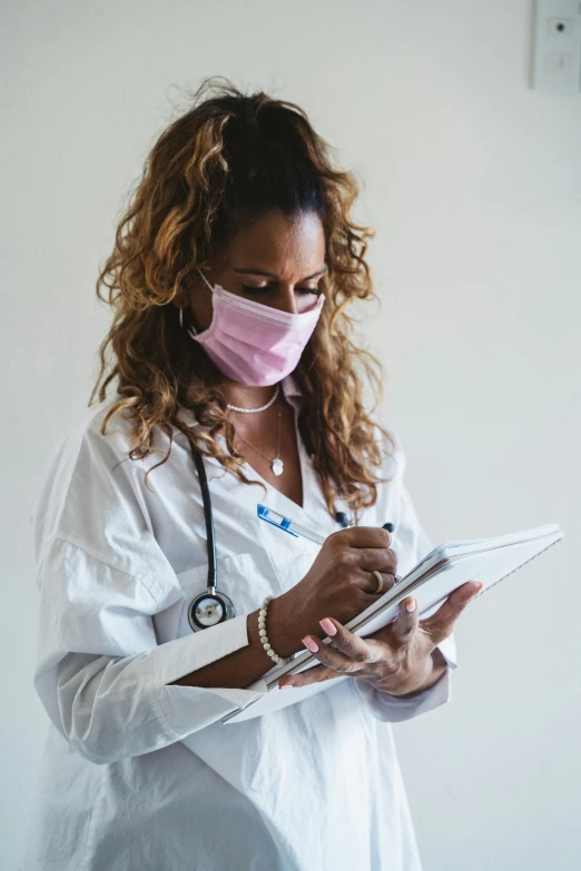 a nurse in scrubs is checking her notes